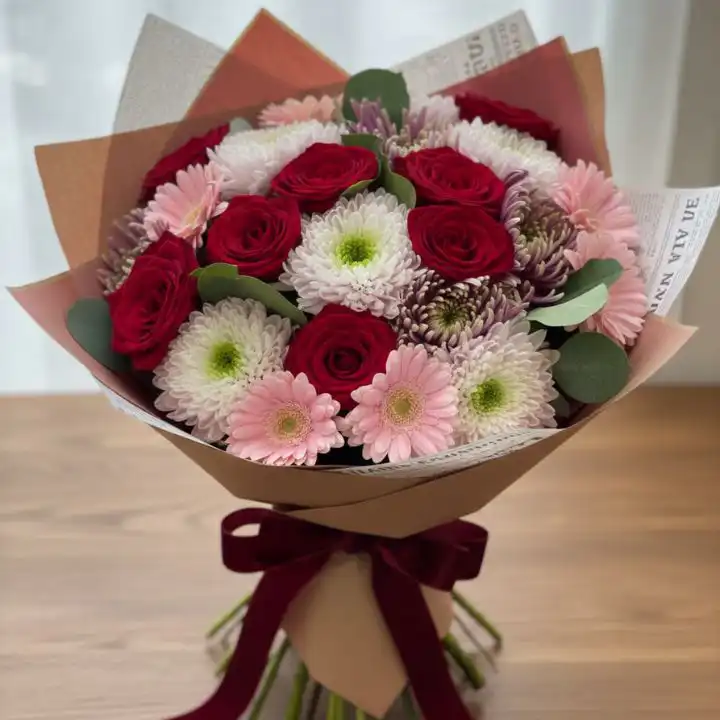 Romantic Rose & Chrysanthemum Bliss Bouquet 1 Hand-tied rose and chrysanthemum bouquet featuring deep red roses and white blossoms wrapped in vintage newspaper style paper.