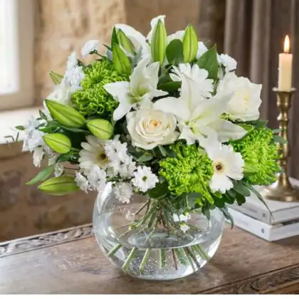 A serene white lily and white rose bouquet elegantly arranged with lush green foliage.