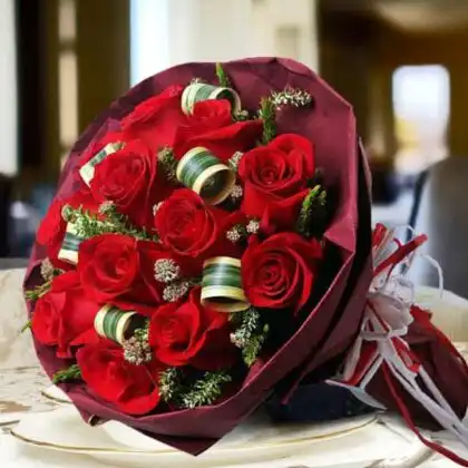 A beautifully arranged bouquet of vibrant red roses in a bouquet with elegant wrapping.