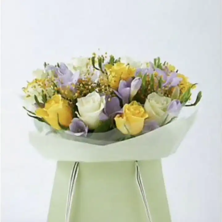 Radiant Rose & Freesia Delight 1 A hand-tied rose and freesia bouquet featuring soft pastel blooms and lush greenery in a decorative wrap.