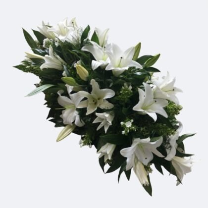 A large and elegant White Lily Casket Spray arranged with lush greenery for a funeral tribute.