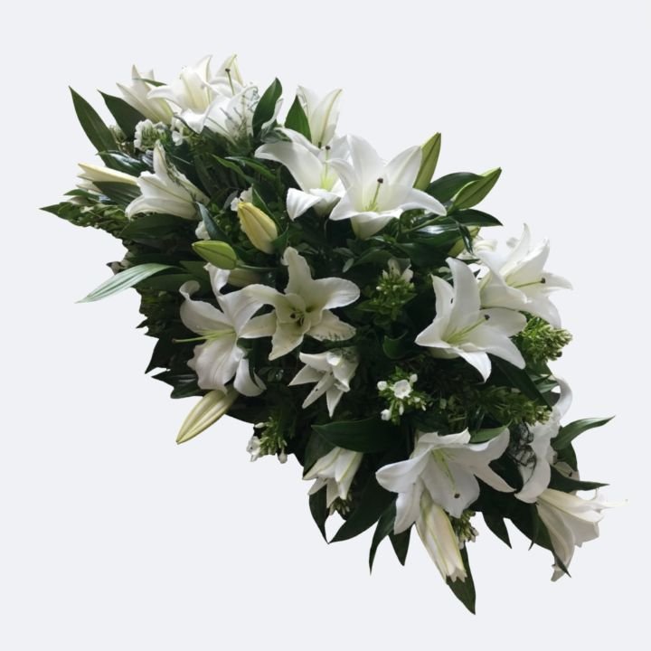 White Lily Casket Spray 1 A large and elegant White Lily Casket Spray arranged with lush greenery for a funeral tribute.