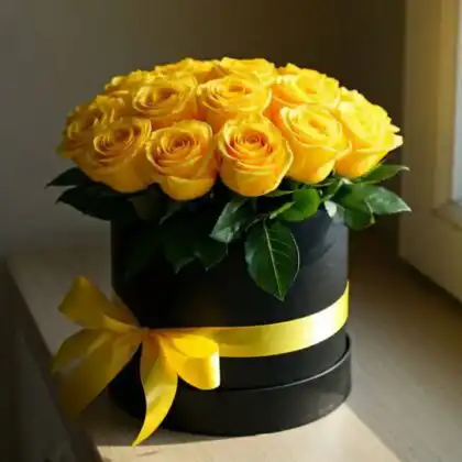 A luxury arrangement of fresh yellow roses in box with a golden ribbon for a premium gift presentation.