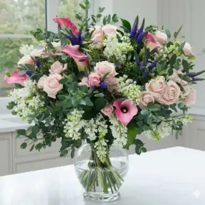 A stunning Velvet Pink Rose & Royal Lily Artisan Bouquet arranged with lush greenery in a professional studio setting.