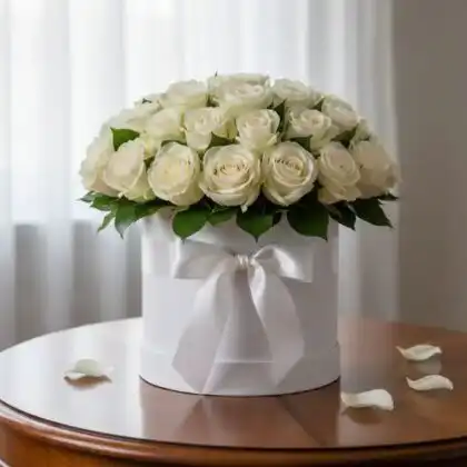A luxurious arrangement of fresh white roses in a hat box placed on a clean background for elegant gifting.