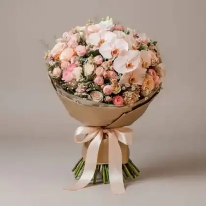 A stunning peach bliss orchid and rose bridal bouquet arranged with fresh blossoms for a sophisticated wedding look.