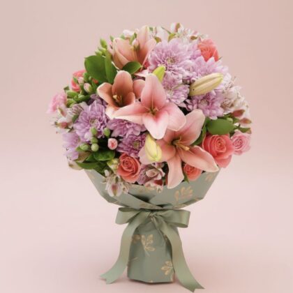 A hand-tied chrysanthemum and lily bouquet featuring vibrant pink petals and fresh white blossoms in a decorative wrap.