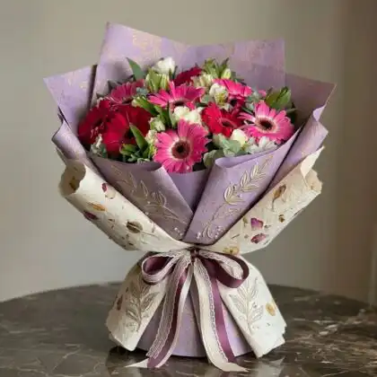 A vibrant pink gerberas bouquet mixed with elegant white alstroemeria and green foliage.