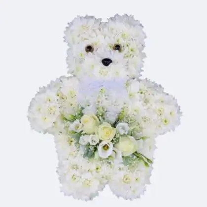 A Teddy Bear Funeral Flowers Tribute crafted with white chrysanthemums featuring a central rose bouquet and a ribbon.