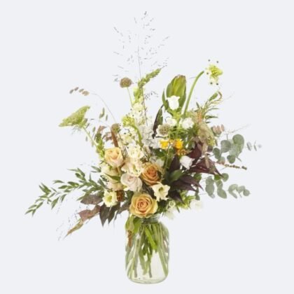 A Burnished Blossom Bouquet with peach roses, white lisianthus, and wild greenery arranged in a clear glass mason jar.