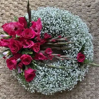 A luxury hot pink rose wreath arranged with vibrant artificial flowers for elegant interior wall decoration.