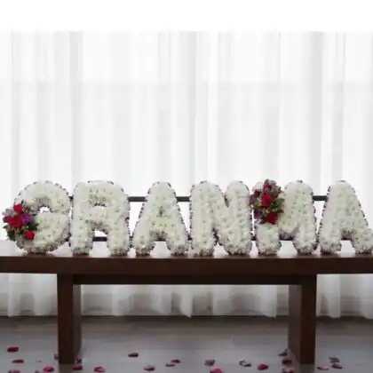 A serene and elegant arrangement of white lilies and roses as grandma funeral flowers for a memorial service.