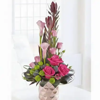 A stunning purple calla lily bouquet with roses arranged in a sleek rose-gold vase on a minimalist background.