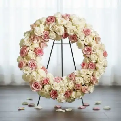 A serene white rose funeral wreath with subtle pink accents, perfect for a respectful memorial service.