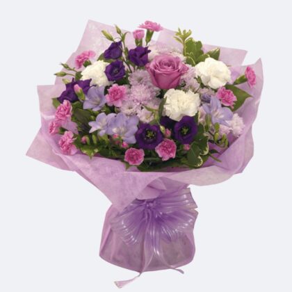 Vibrant New Princess Bouquet featuring purple lisianthus and pink carnations wrapped in elegant lavender paper.