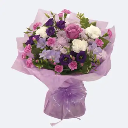 Vibrant New Princess Bouquet featuring purple lisianthus and pink carnations wrapped in elegant lavender paper.