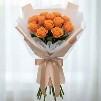 A hand-tied 18 orange rose bouquet wrapped in elegant peach paper with a silk ribbon.