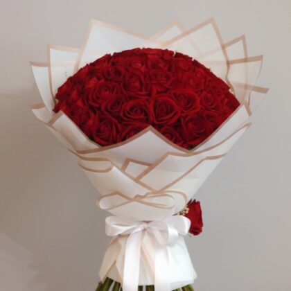 A fresh 18 red roses bouquet arranged beautifully in a clear glass vase for a romantic gift.