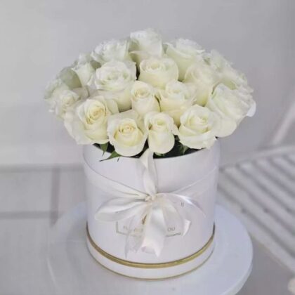 A luxury dome shaped bouquet roses white arranged in a minimalist white hatbox with a silk ribbon.