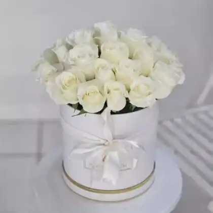 A luxury dome shaped bouquet roses white arranged in a minimalist white hatbox with a silk ribbon.
