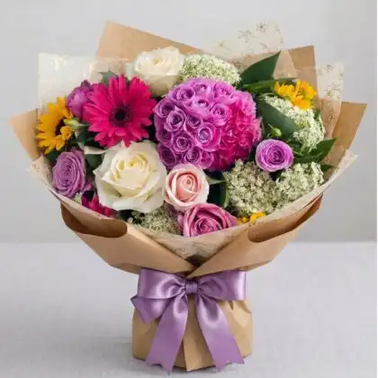 A vibrant hand-tied sunflower and rose bouquet featuring bright yellow petals and deep red blossoms.