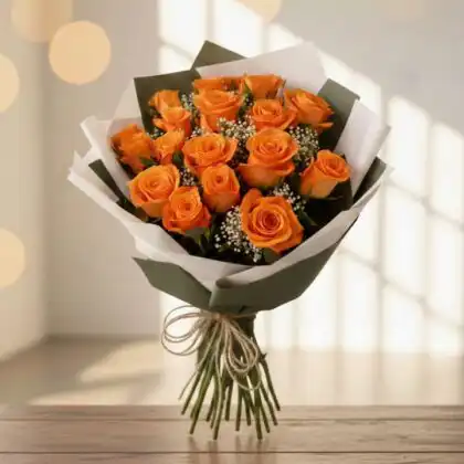 A hand-tied orange rose bouquet wedding arrangement with white gypsophila and green leaves.