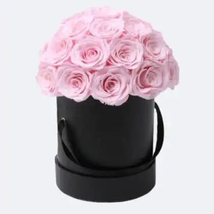 A luxury dome shaped pink rose flower bouquet presented in a matte black hatbox with silk ribbons.