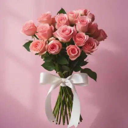A handcrafted premium bouquet roses pink tied with a white satin ribbon against a soft pastel background.