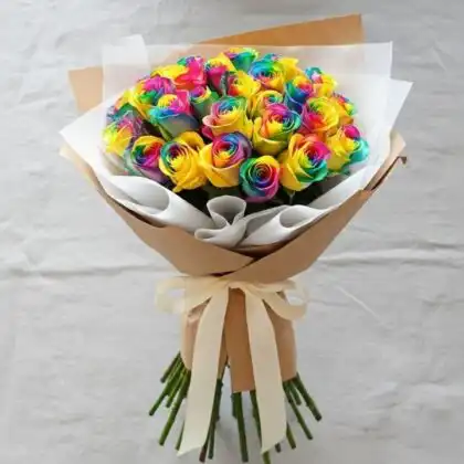 A stunning rainbow rose bouquet with vibrant multicolored petals arranged in a professional hand-tied wrap.