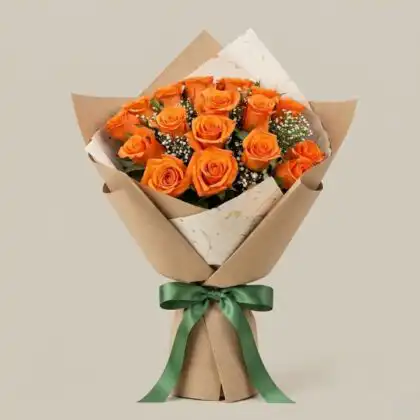 Hand-tied orange rose bridal bouquet with fresh green leaves arranged for a vibrant wedding theme.