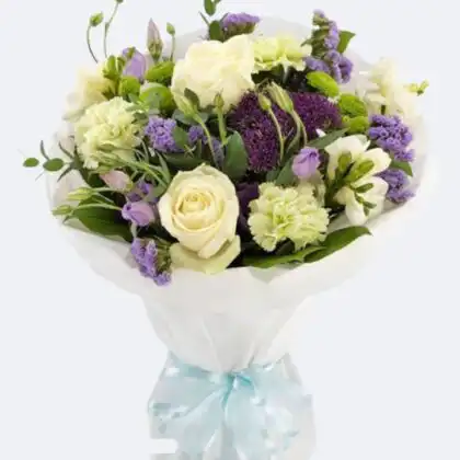 Hand-tied Vintage Bouquet featuring fresh white roses, cream carnations, and vibrant purple statice in white gift wrapping.
