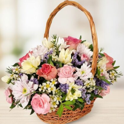 A handcrafted floral gift baskets featuring fresh pink roses and white chrysanthemums in a rustic wicker basket.