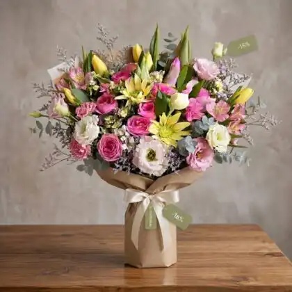 A vibrant flower bouquet tulips and roses featuring delicate pink petals and bright yellow blooms.