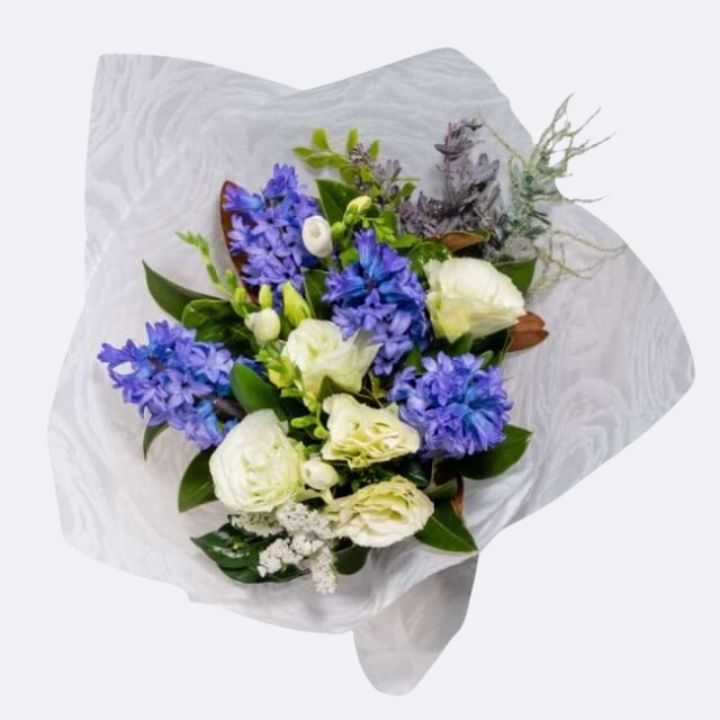 Lisianthus, Hyacinth, and Rose Bouquet 1 A vibrant hyacinth and rose bouquet featuring deep blue blossoms and crisp white petals wrapped in decorative paper.