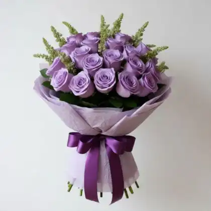 A fresh lilac bouquet rose arrangement featuring premium lavender roses and green astilbe fillers against a neutral background.