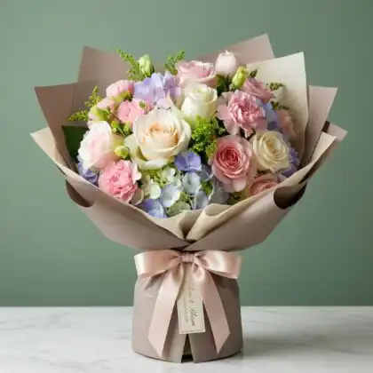 A professional arrangement of a lilac and white rose bouquet with lush green foliage in a studio setting.