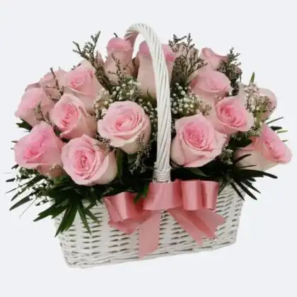 Fresh Pink Rose Arrangement in Basket with lush green leaves and a natural wicker base.