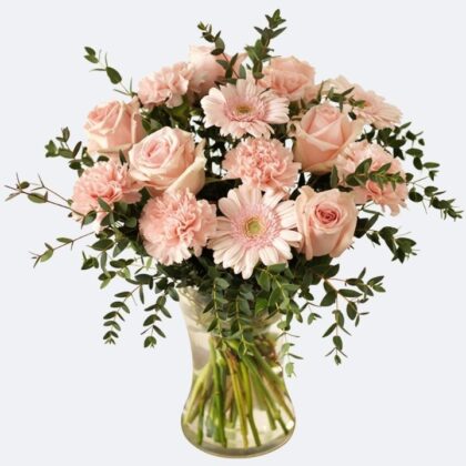 A fresh Pink Rose and Carnation Bouquet with pink gerberas and eucalyptus leaves in a clear glass vase.