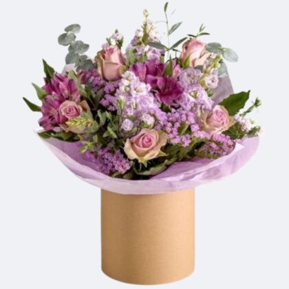 A vibrant rose and alstroemeria bouquet arranged meticulously inside a decorative hatbox, ideal for special occasions.
