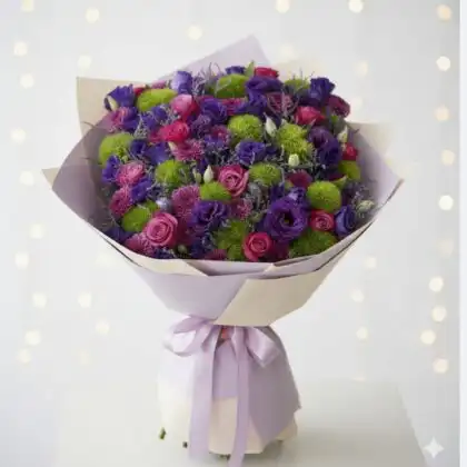 A lush purple lisianthus bouquet mixed with magenta roses and lime green dianthus in premium paper wrapping.