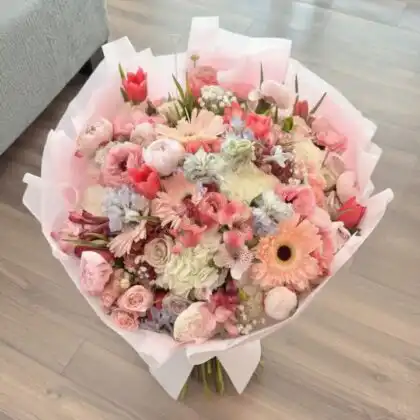 A vibrant Tulip, Gerbera & Chrysanthemum Mixed Bouquet arranged with fresh greenery in a stylish presentation.