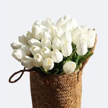 A beautiful arrangement of white Tulip Flower Basket in a rustic woven bag.