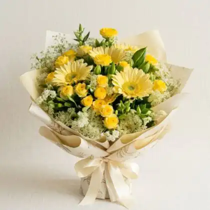 A hand-tied gerbera daisy and roses bouquet featuring bright yellow petals and elegant white blossoms in natural light.