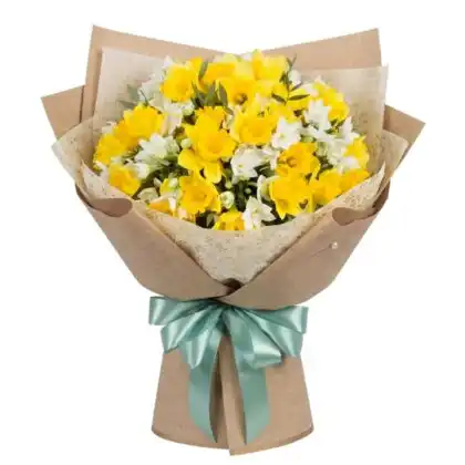 A rustic hand-tied Yellow and White Daffodil Freesia Bouquet wrapped in brown kraft paper with a teal satin ribbon.