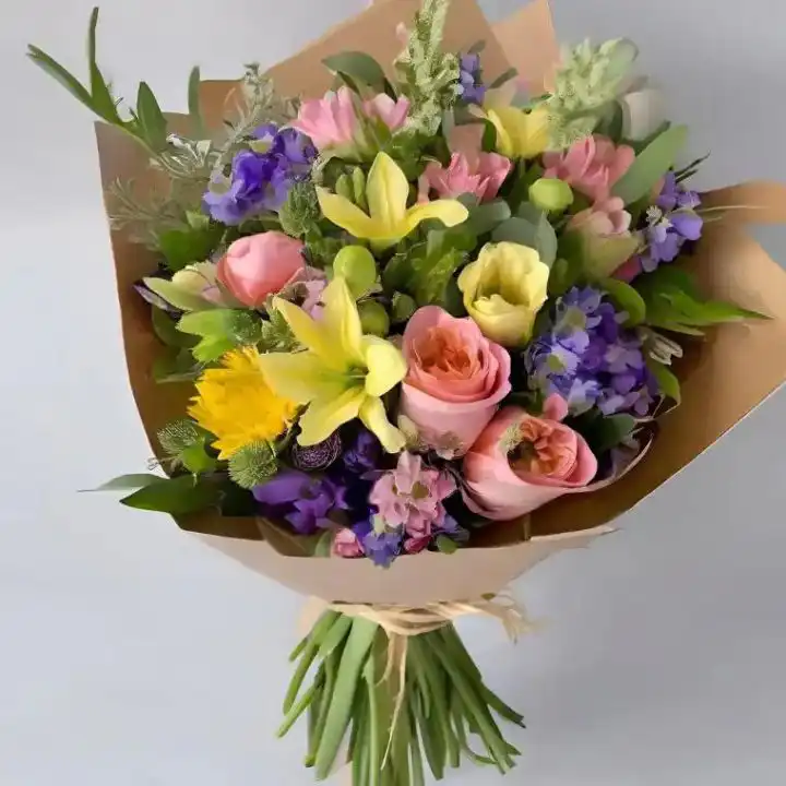 The Classic Lily & Rose Bouquet 1 A hand-tied bouquet with lilies and roses arranged with lush green foliage in a stylish wrap.