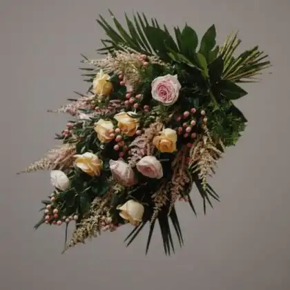 An elegant sheaf funeral flowers arrangement featuring fresh peach and pink roses with seasonal greenery.