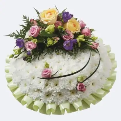 A serene and elegant white funerals posy featuring fresh seasonal blossoms arranged in a circular memorial tribute.