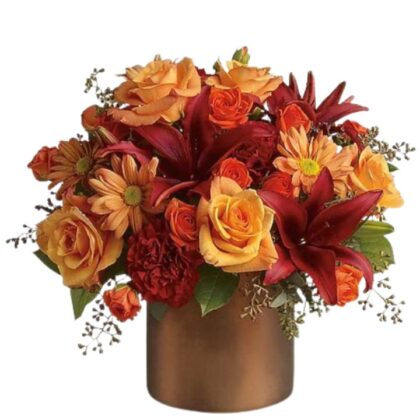 A rich Autumn Falls Table Arrangement in a metallic bronze vase with orange roses, red lilies, rust mums, and seasonal greenery.