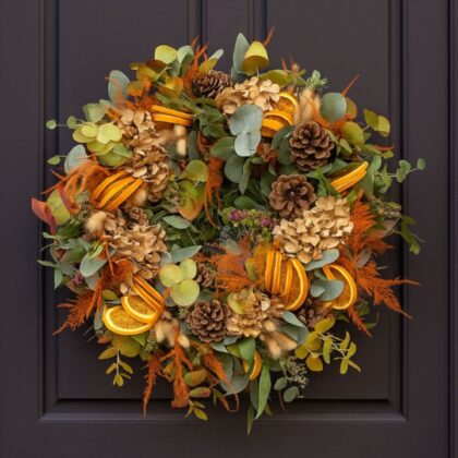 A vibrant arrangement featuring orange and yellow gerbera daisies, roses, and foliage, which are ideal components for crafting an elegant Autumn door wreath.