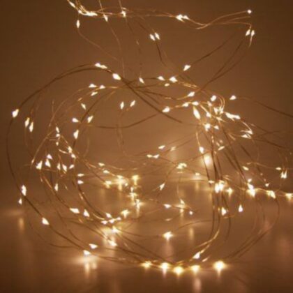 A close-up of a glowing bundle of flexible LED micro wire Christmas lights on a thin copper-coloured wire.